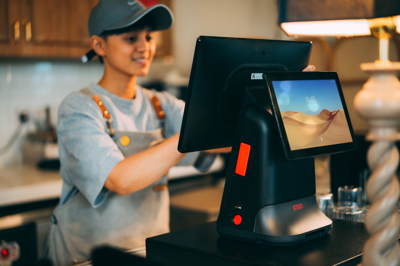 Mastering the First Impression: Your intriguing post title goes here A cashier using a modern point of sale terminal in a store.