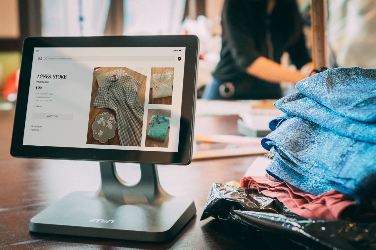 The Art of Drawing Readers In: Your attractive post title goes here A digital point-of-sale system in a small fashion boutique with clothes displayed on a tablet.