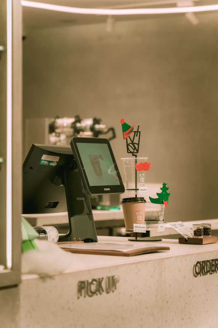 A sleek coffee shop counter with a modern design in Ho Chi Minh City featuring festive decorations.